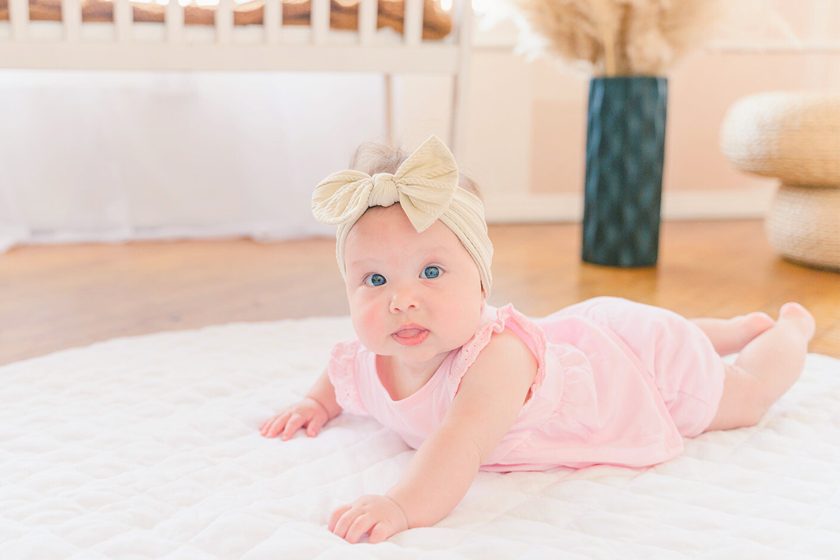 Baby doing Tummy Time on White Play Mat by Poppyseed Play