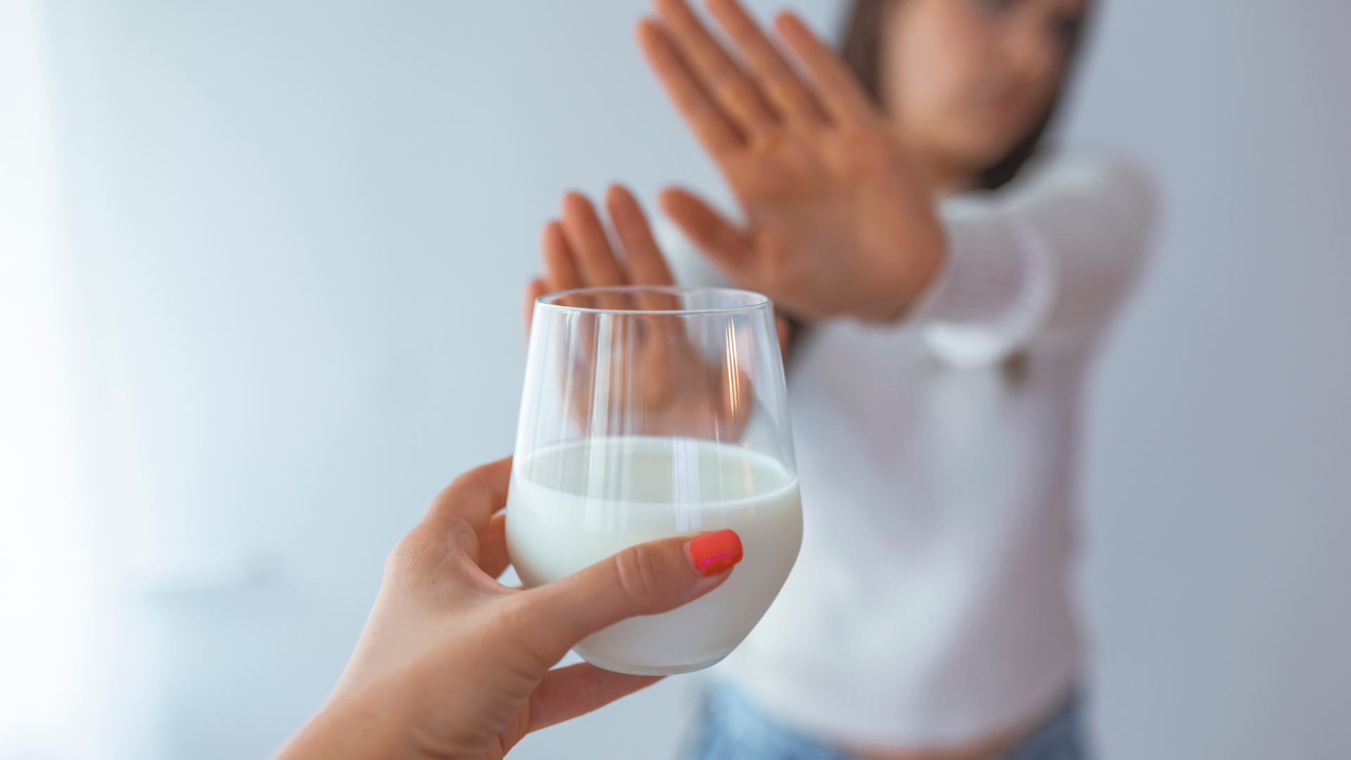 woman rejecting a glass of milk