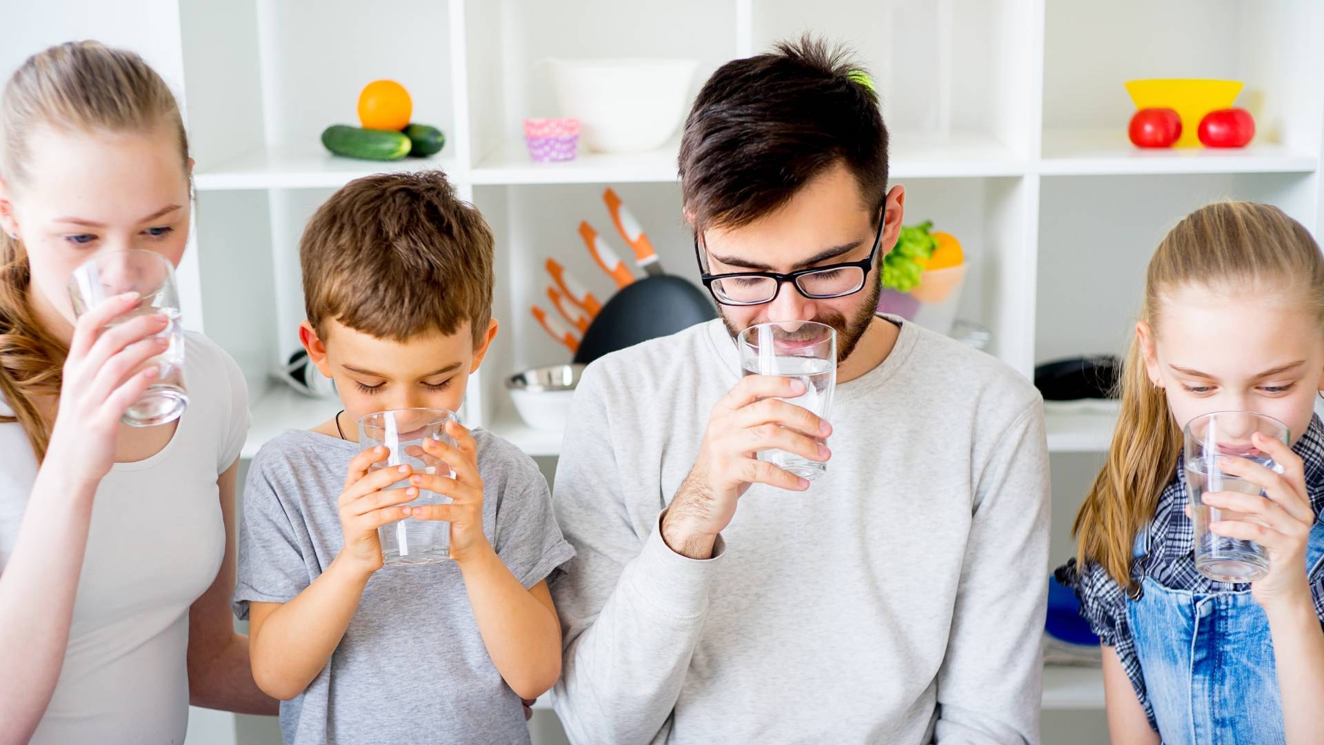 Rodzina pijąca wodę z filtra ro który poprawia parametry wody