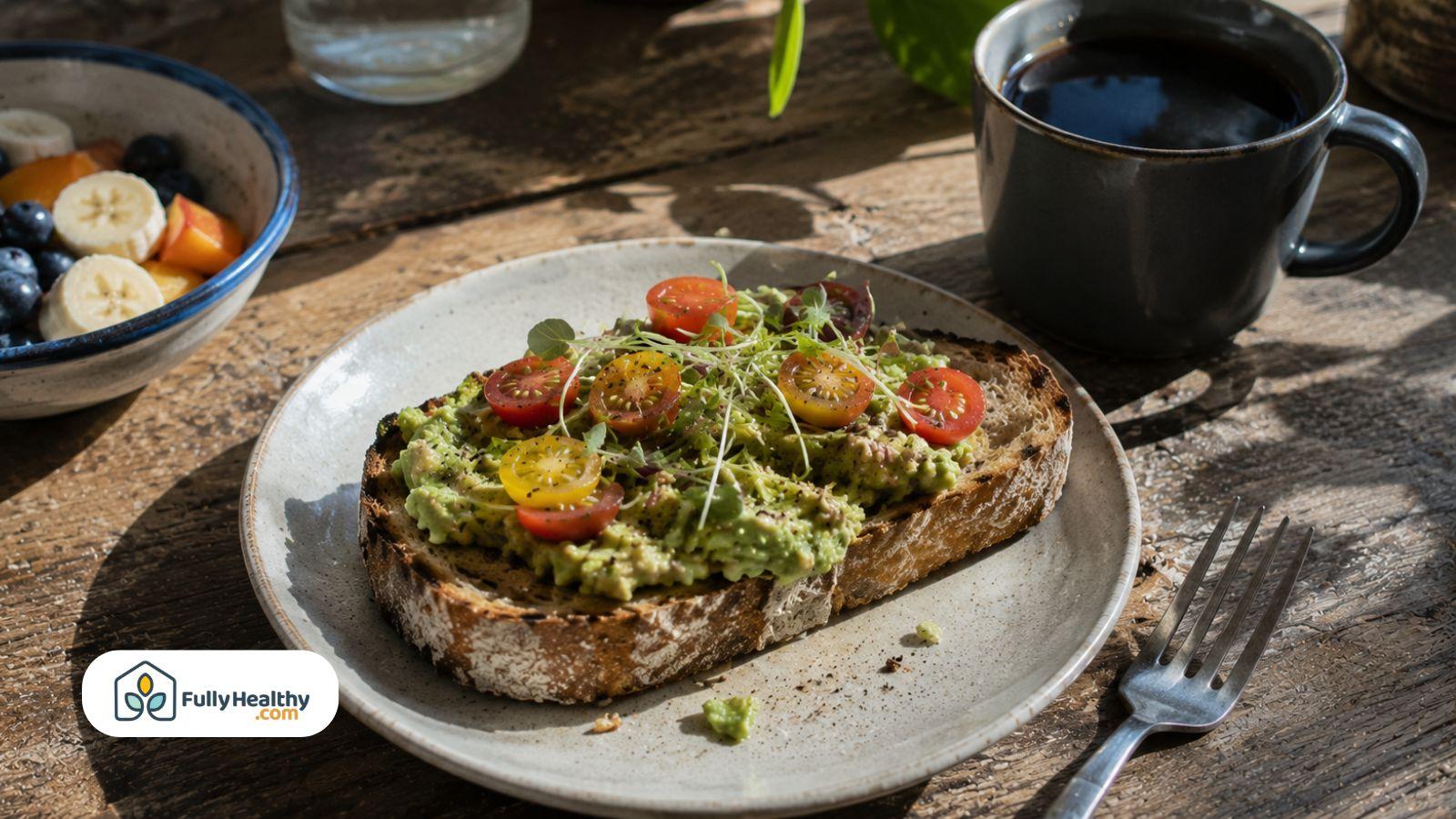 Vegan avocado toast on toasted sourdough bread served with fresh fruit and black coffee.