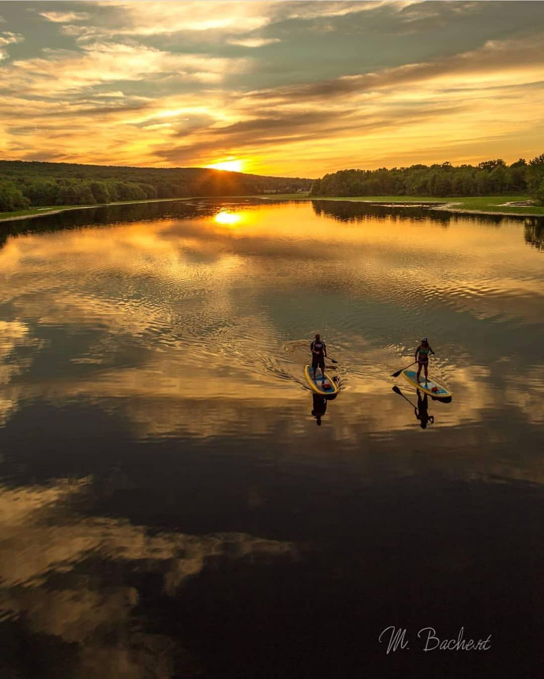 paddling stand up paddle boards at sunset