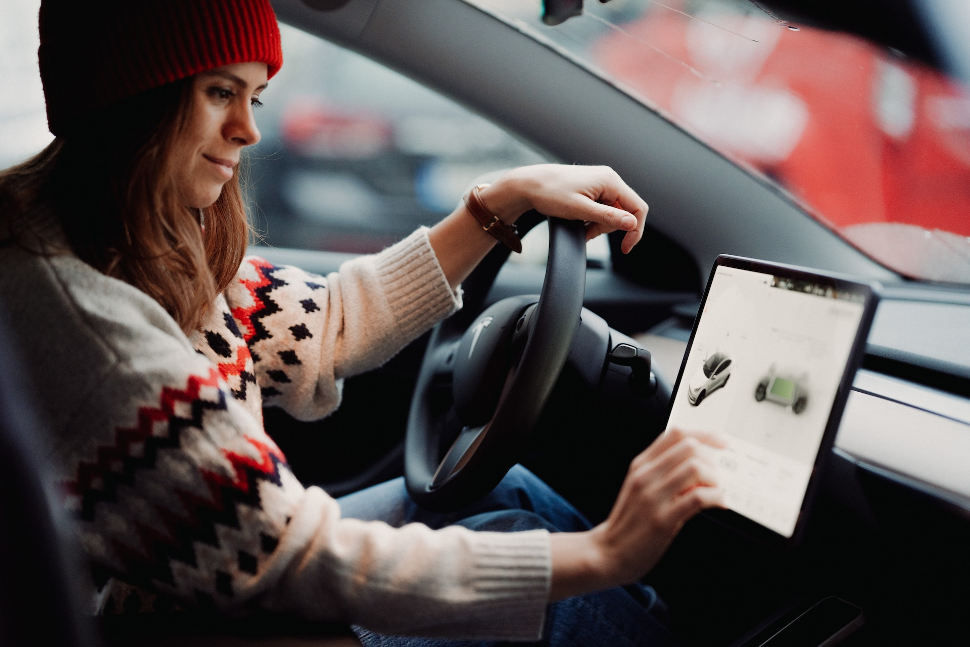 Woman selecting charging options from inside her Tesla. 