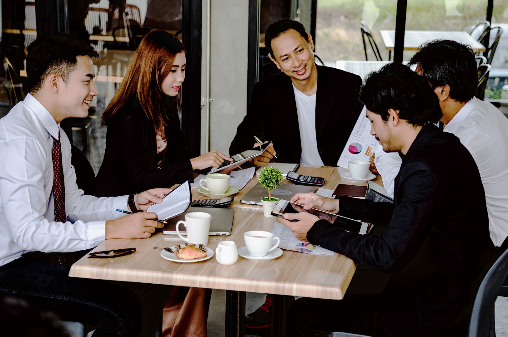 Business professionals discussing reports during a corporate meeting.