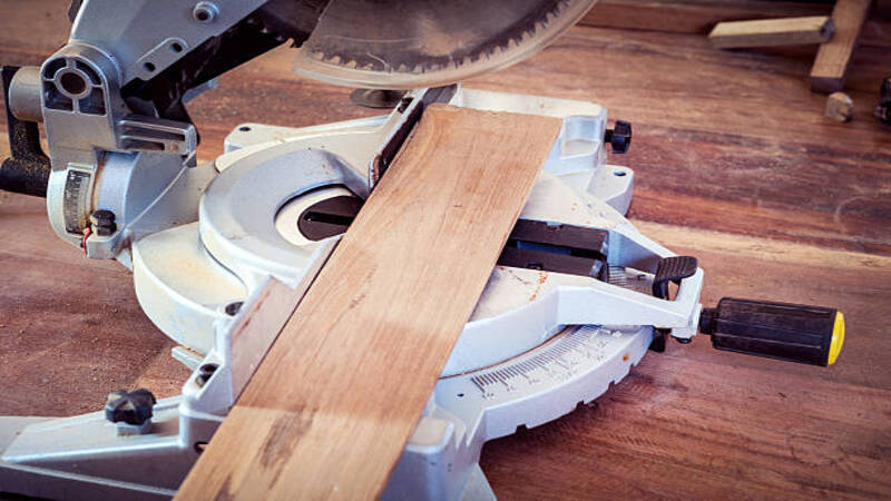 A circular cutter going to make a bevel cut at the edge of the wooden sheet. 