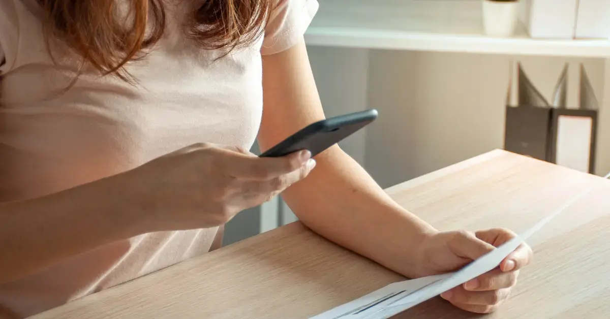 Female scanning receipts for how to organize receipts for taxes using digital tools.