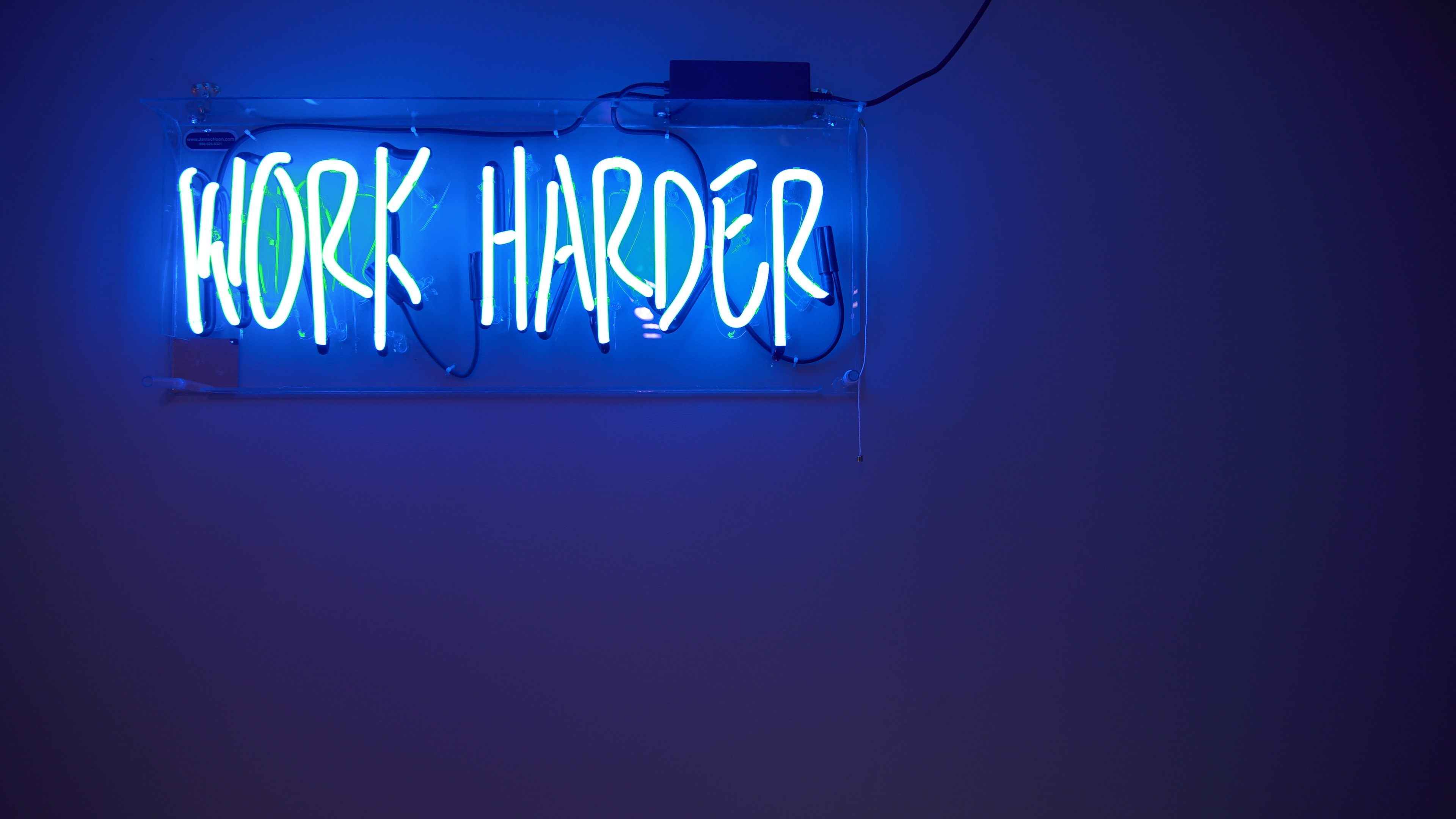 Neon sign that says, WORK HARDER. The best car shipping companies work harder and more efficiently for you.