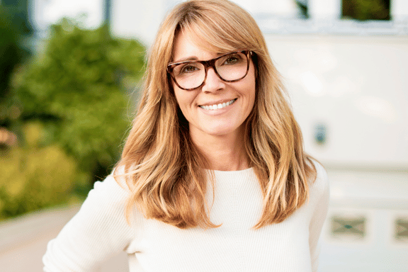 blonde middle aged woman smiling who is a healthy good candidate for dental implants