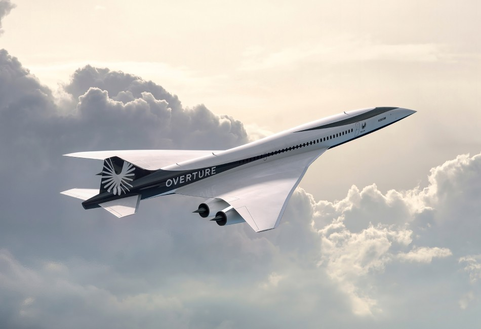 Boom supersonic aircraft flying above clouds.