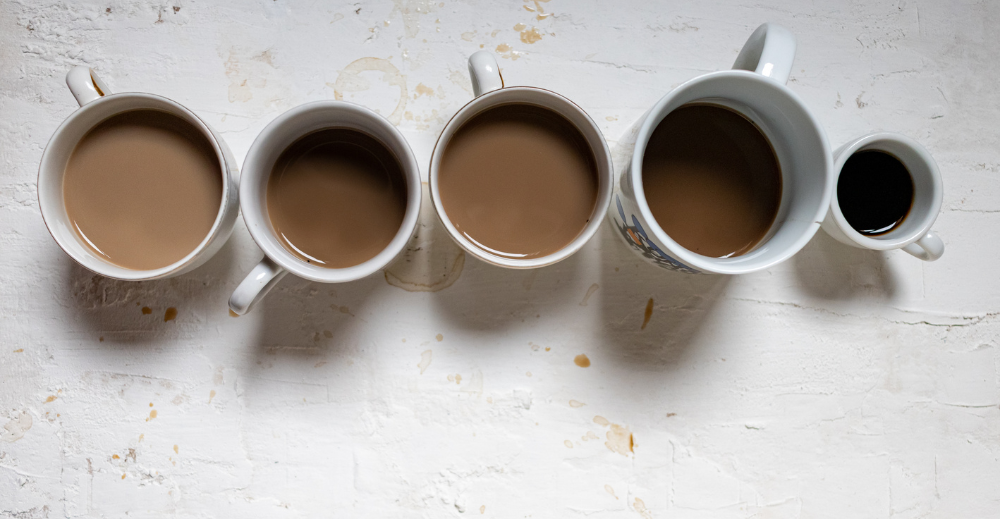 top view of five cups of various coffee on a white background