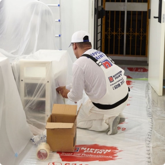 nippon worker setting up plastic before painting 