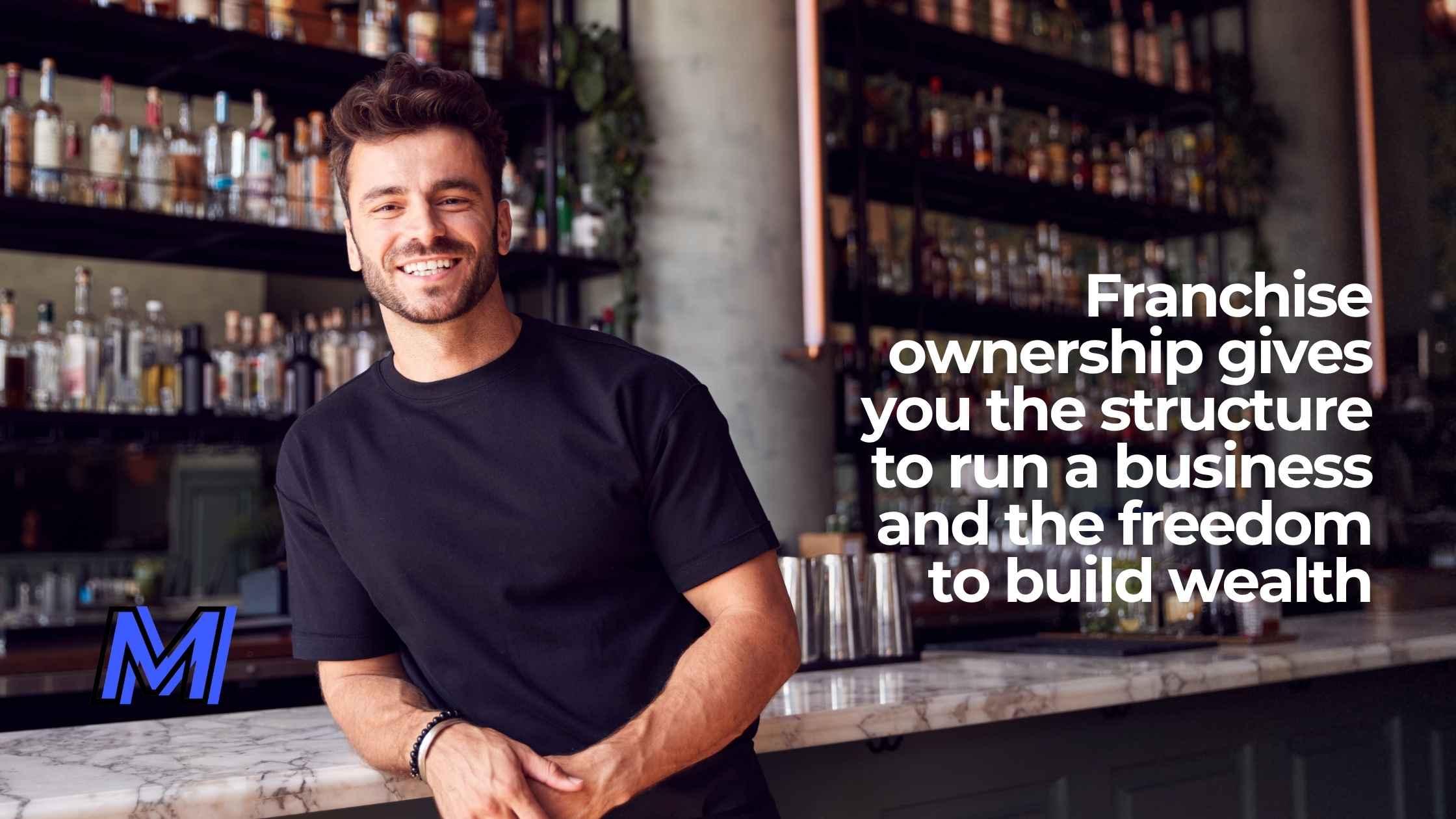 A man standing by a bar smiling who owns the bar with a quote about franchise ownership