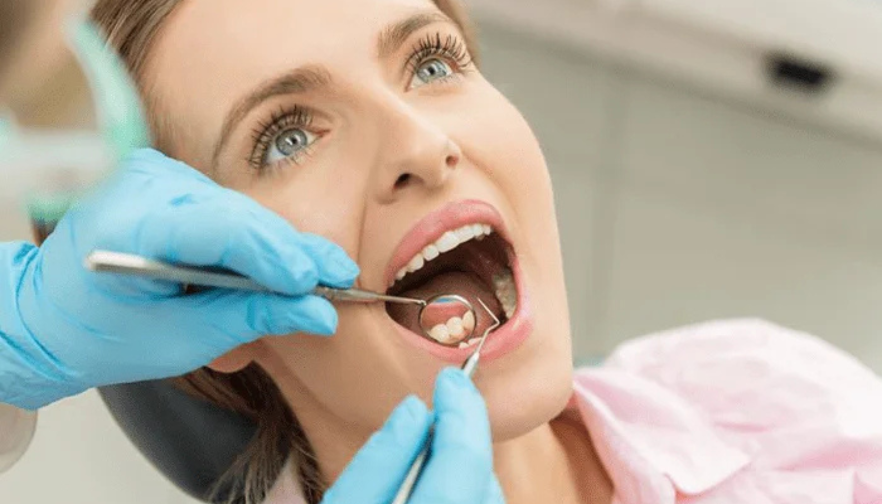 Kvinne får tannundersøkelse med speil og sonde hos tannhelsepersonell.
