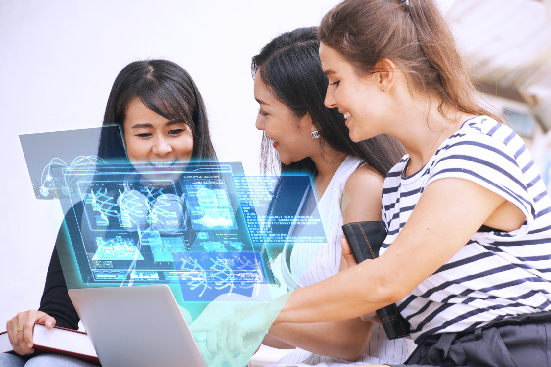 Three women reviewing AI-generated analytics on a laptop, showing team collaboration using AI for market analysis.