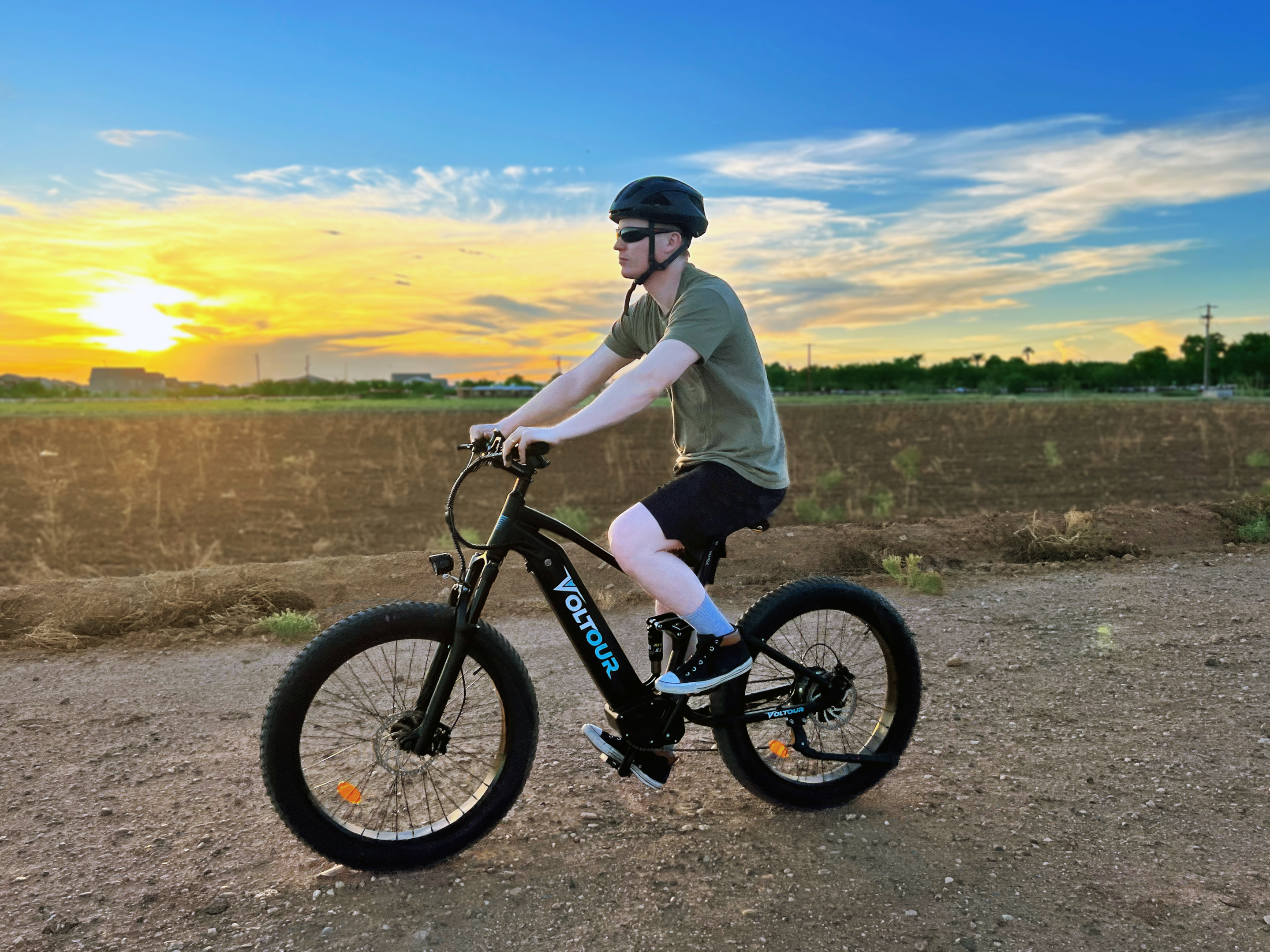 person riding ebike with sunset