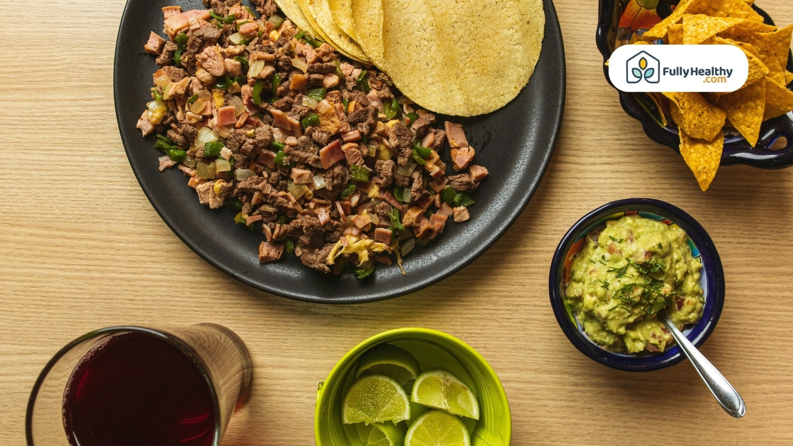 Beef, ham, and onion mix with tortillas, guacamole, and lime.