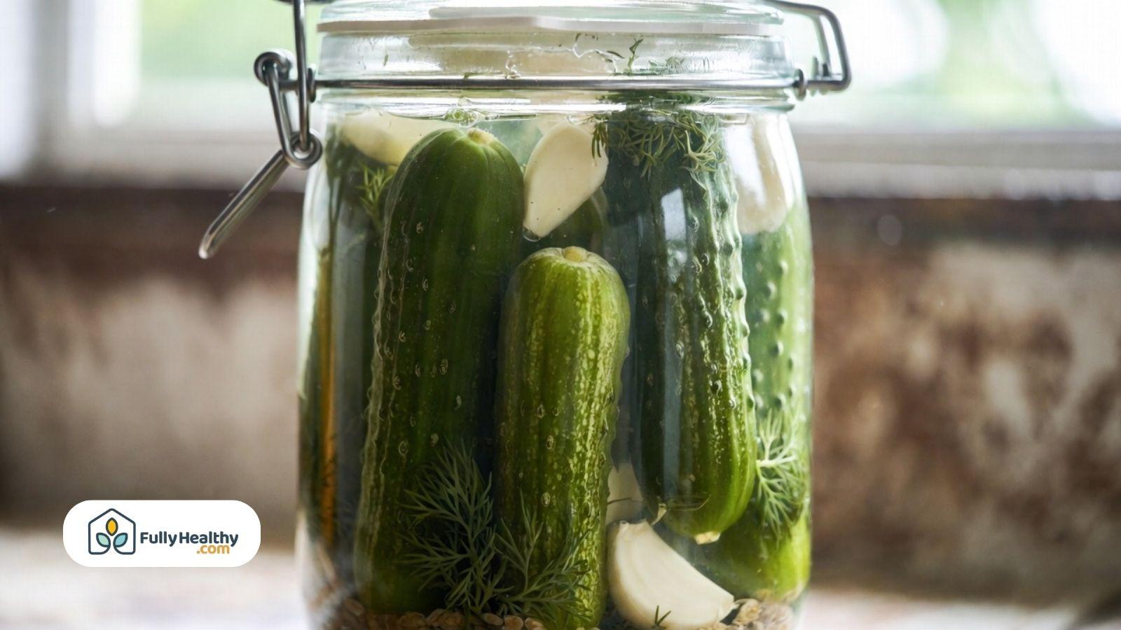 Jar of pickled cucumbers with garlic and herbs in brine.