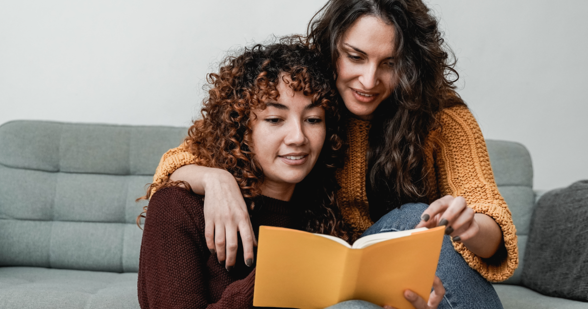 Lesbian couple reading a book together after completing successful lesbian couples counseling in New York at Loving at Your Best Marriage and Couples Counseling.