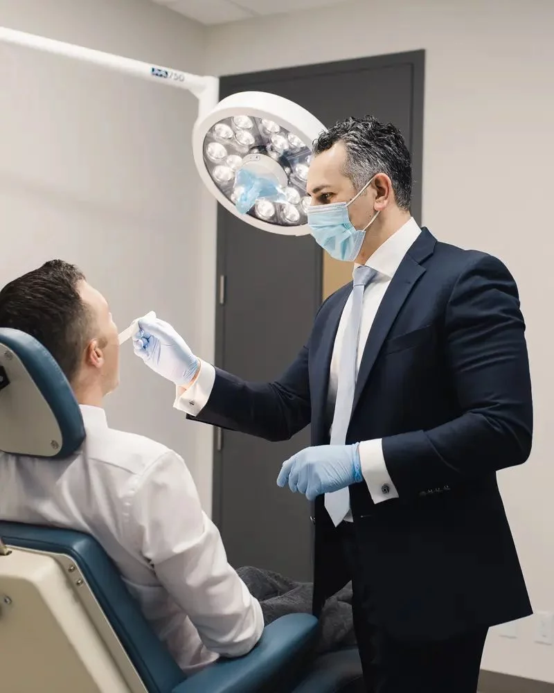 an oral surgeon checking for signs of infection after wisdom teeth removal