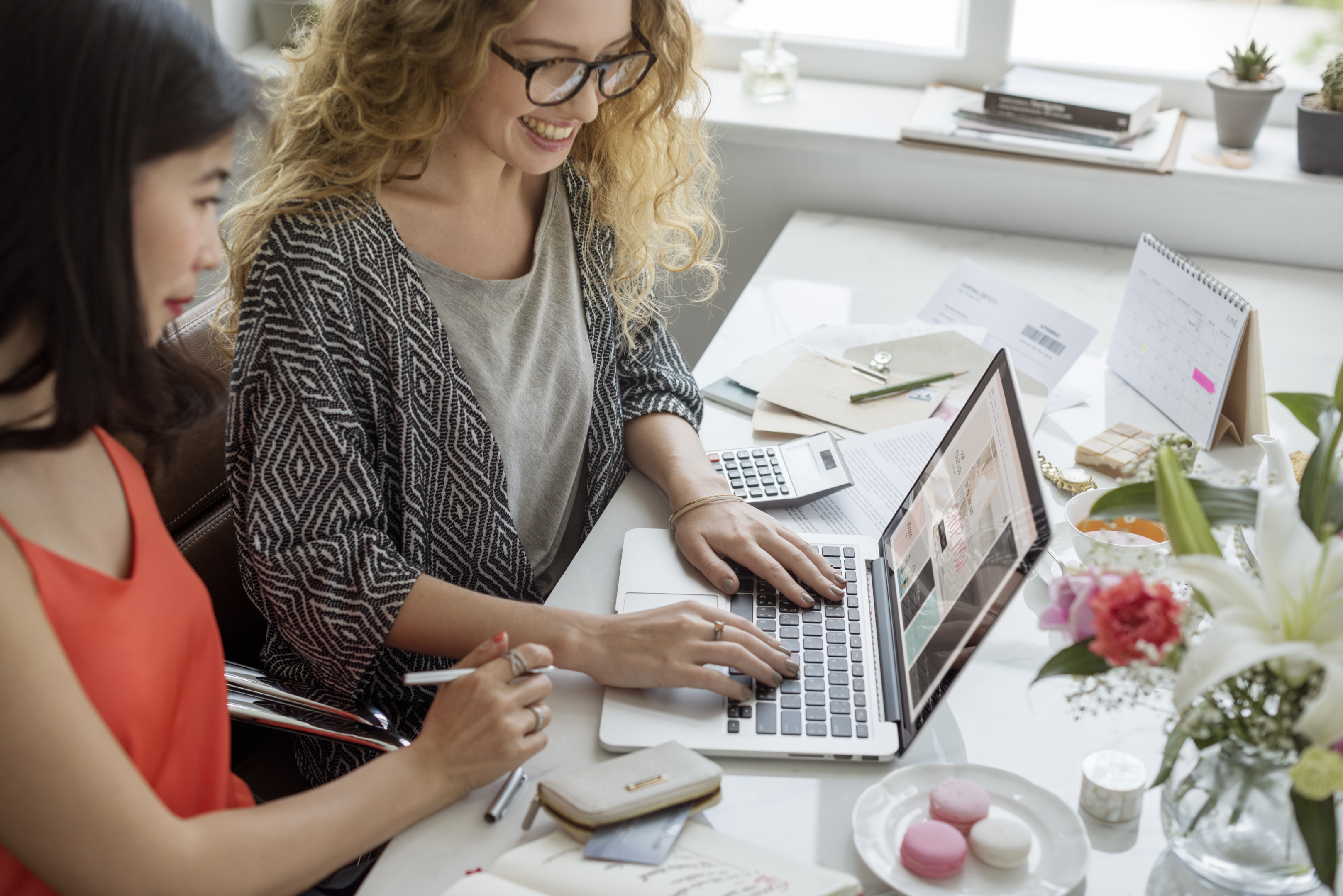 Two women viewing a website on laptop