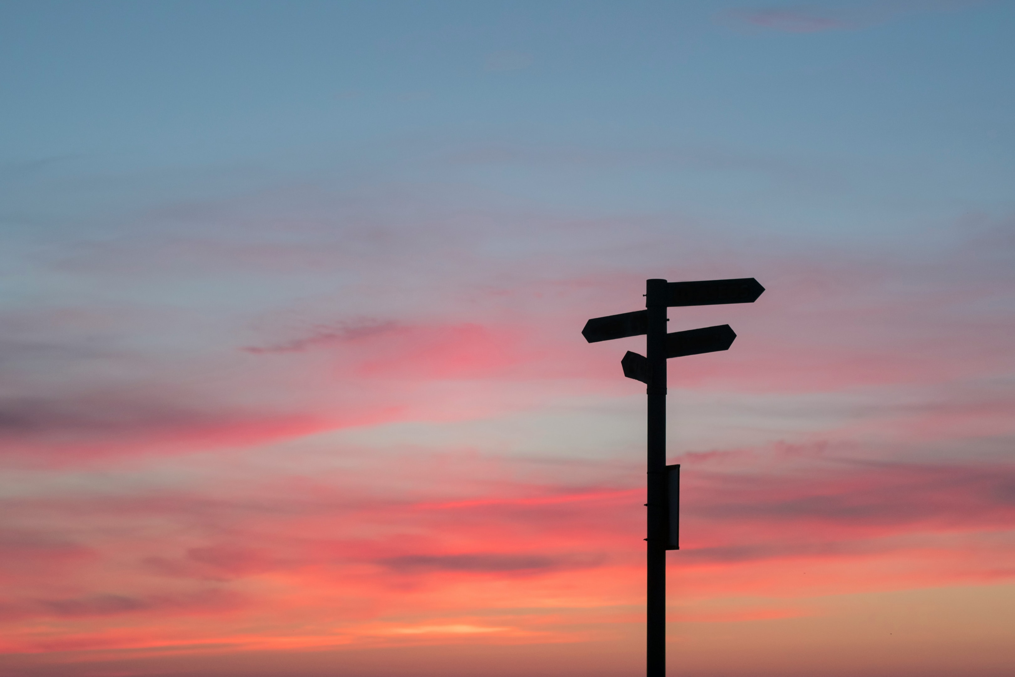 Sunset and a sign that point to three ways