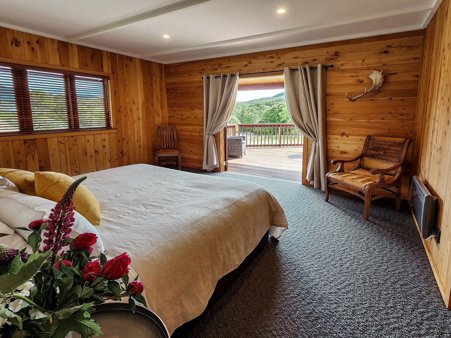 A well-appointed bedroom looking out over a beautiful New Zealand landscape.