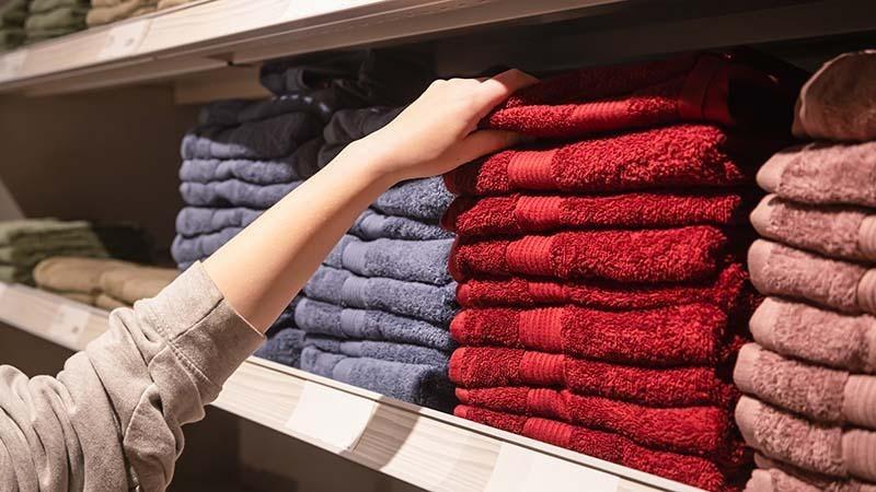 A woman picking a towel from deep pile of microfiber