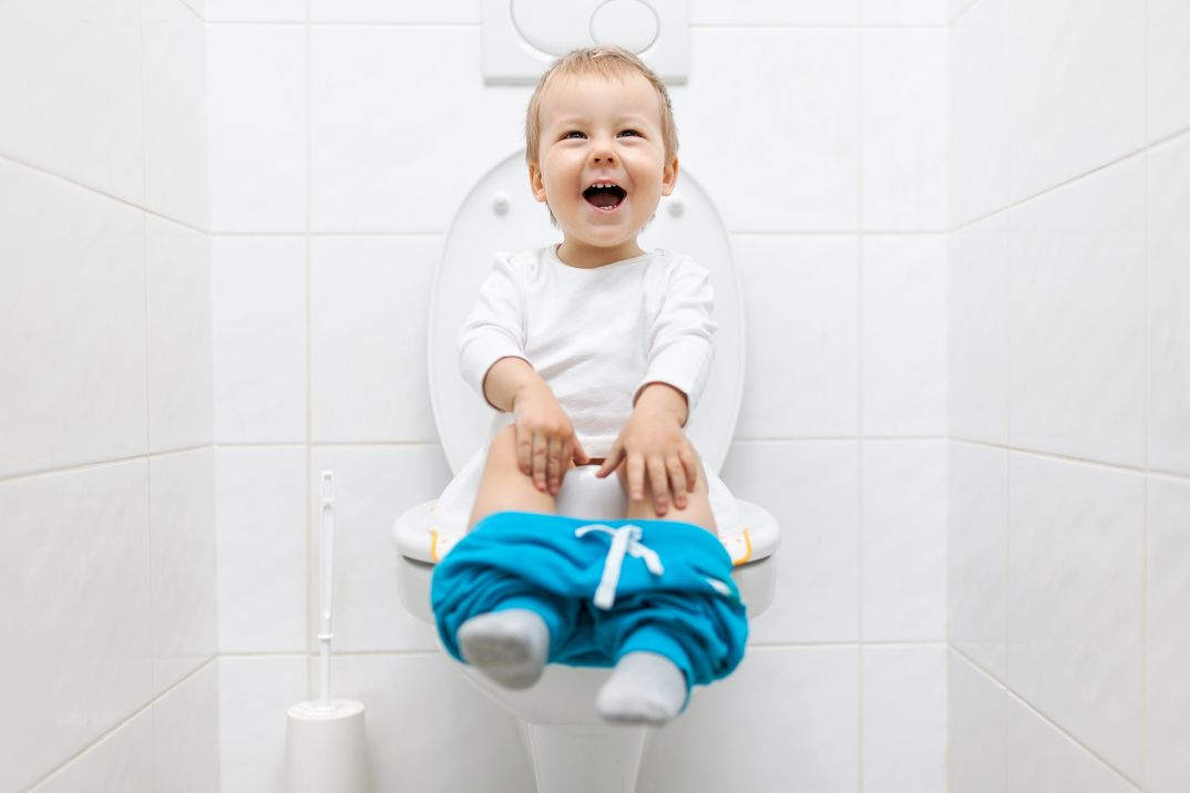 Little boy sitting on the toilet smiling