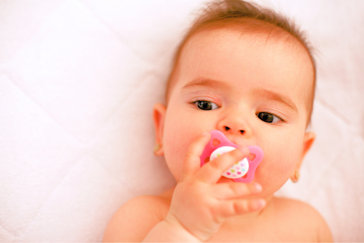 Newborn with binkie and pacifier in mouth