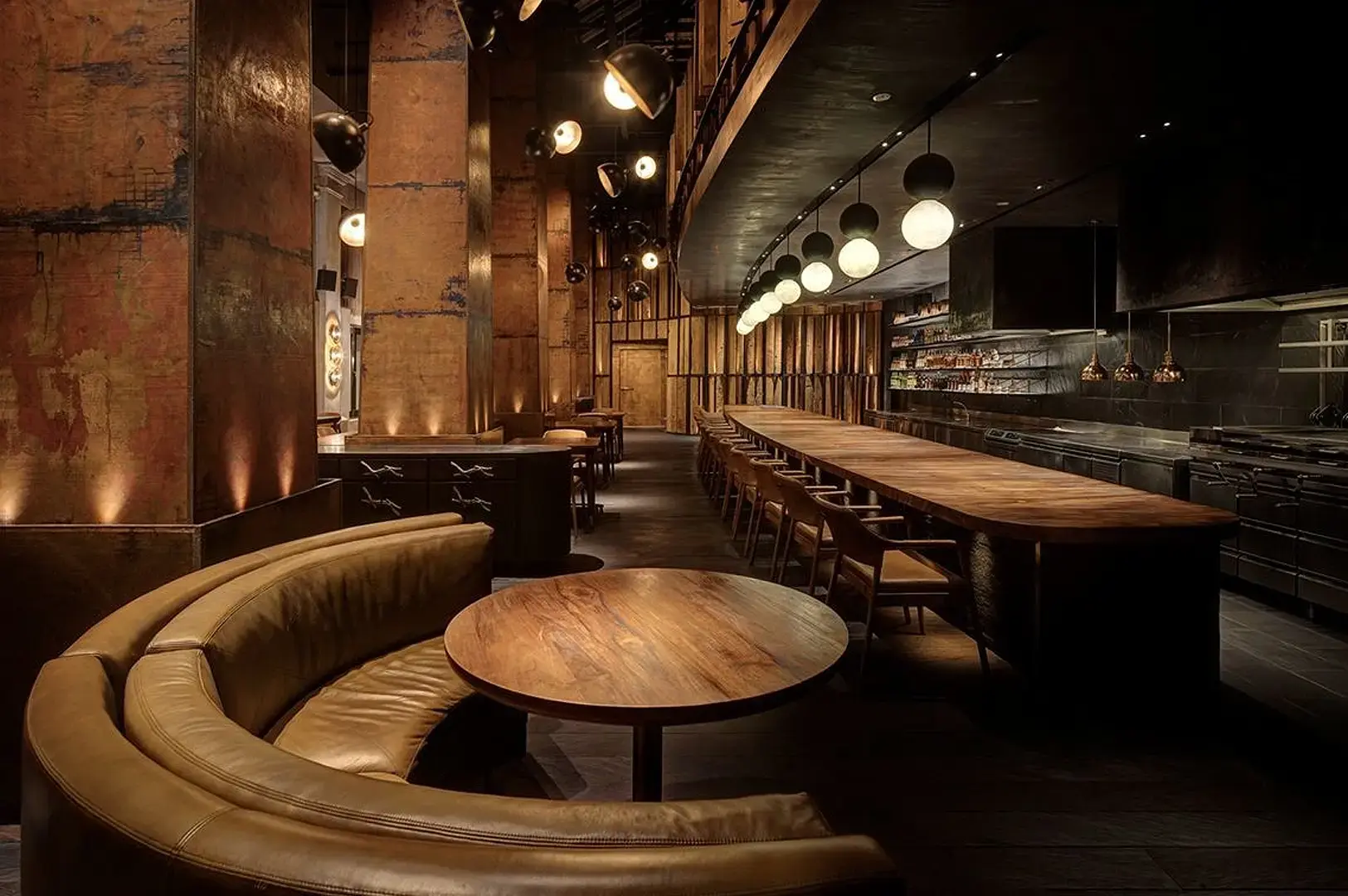Singapore steakhouse interior with long wooden dining table, leather seating, bar and warm ambient lighting