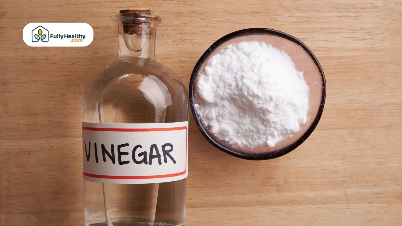 Glass bottle of vinegar and bowl of white baking soda