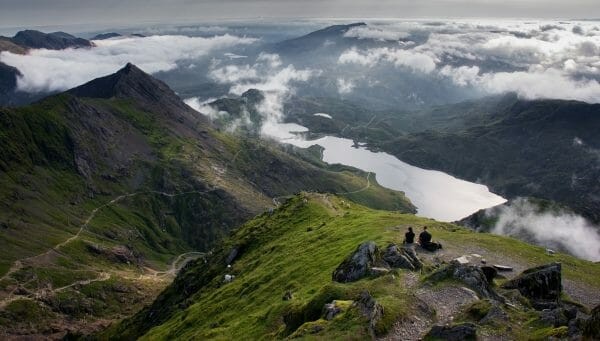 Two people sitting on the summit of Snowdon