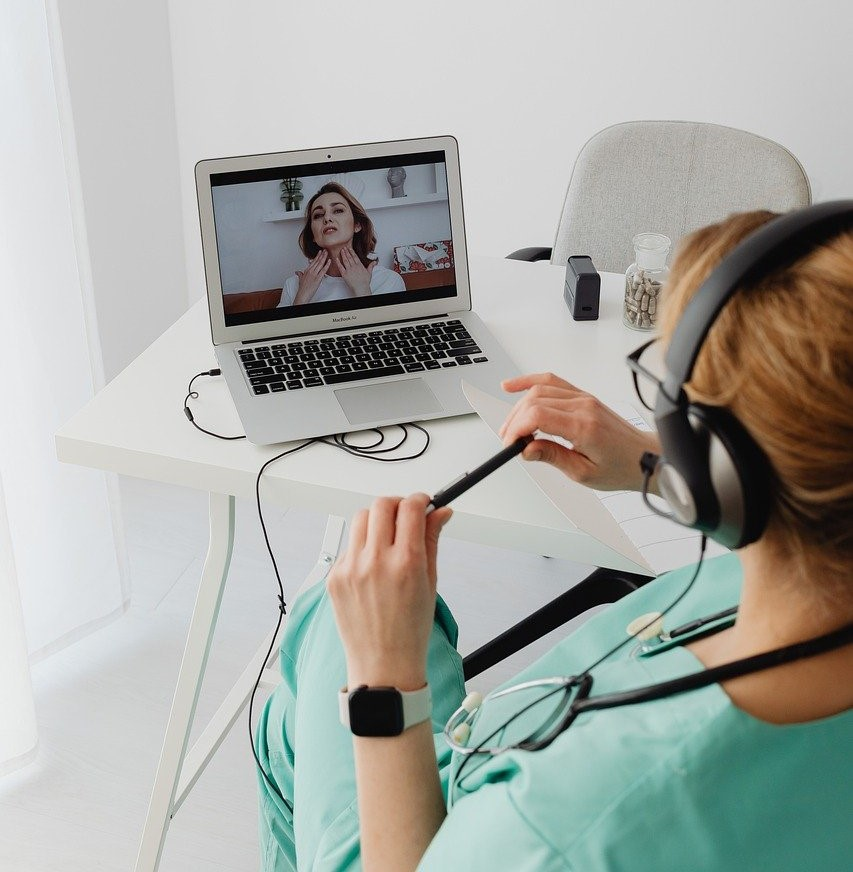 Doctor treating a young woman via telemedicine.