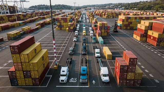 A picture of commercial fleets line up on a road; Fleet of vehicles