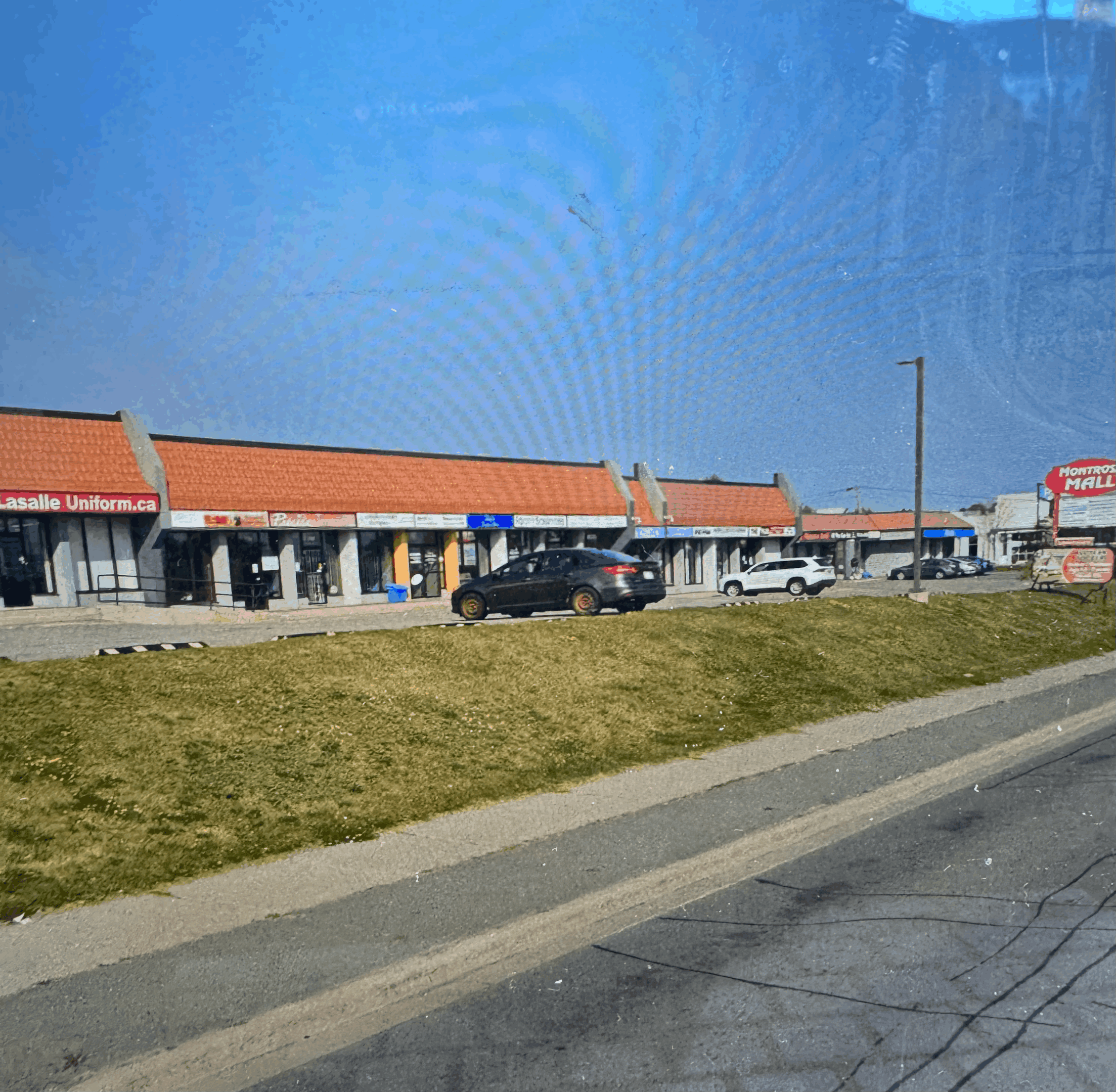 A commercial building complex with a red metal roof - an ideal example of long-lasting metal roofing for Ontario businesses.
