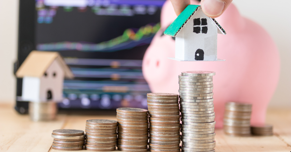 Rentvesting - dummy house and coins infront of a laptop