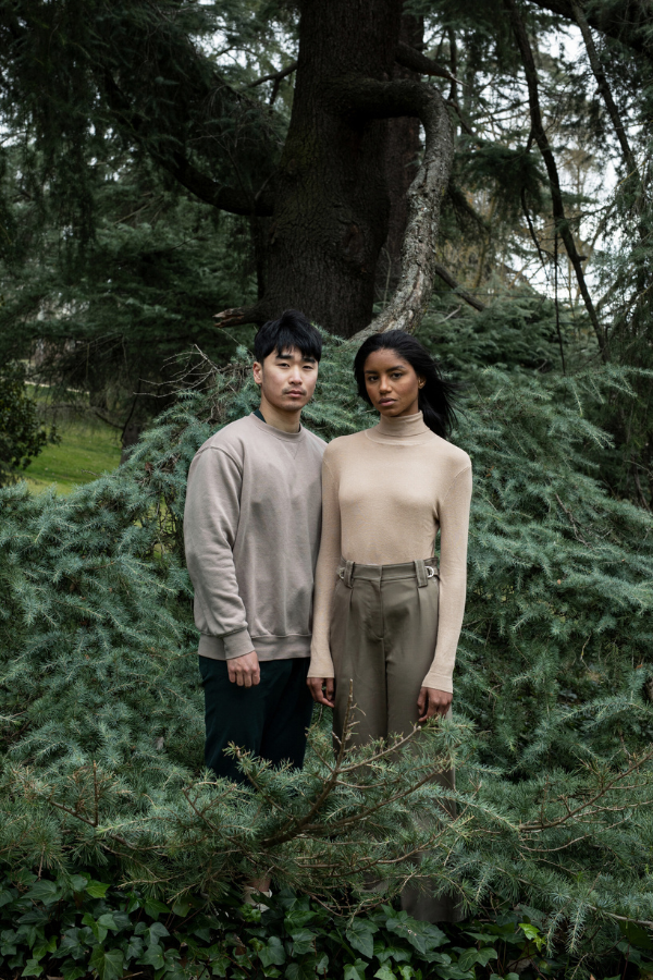 a couple stand together in a wooded area