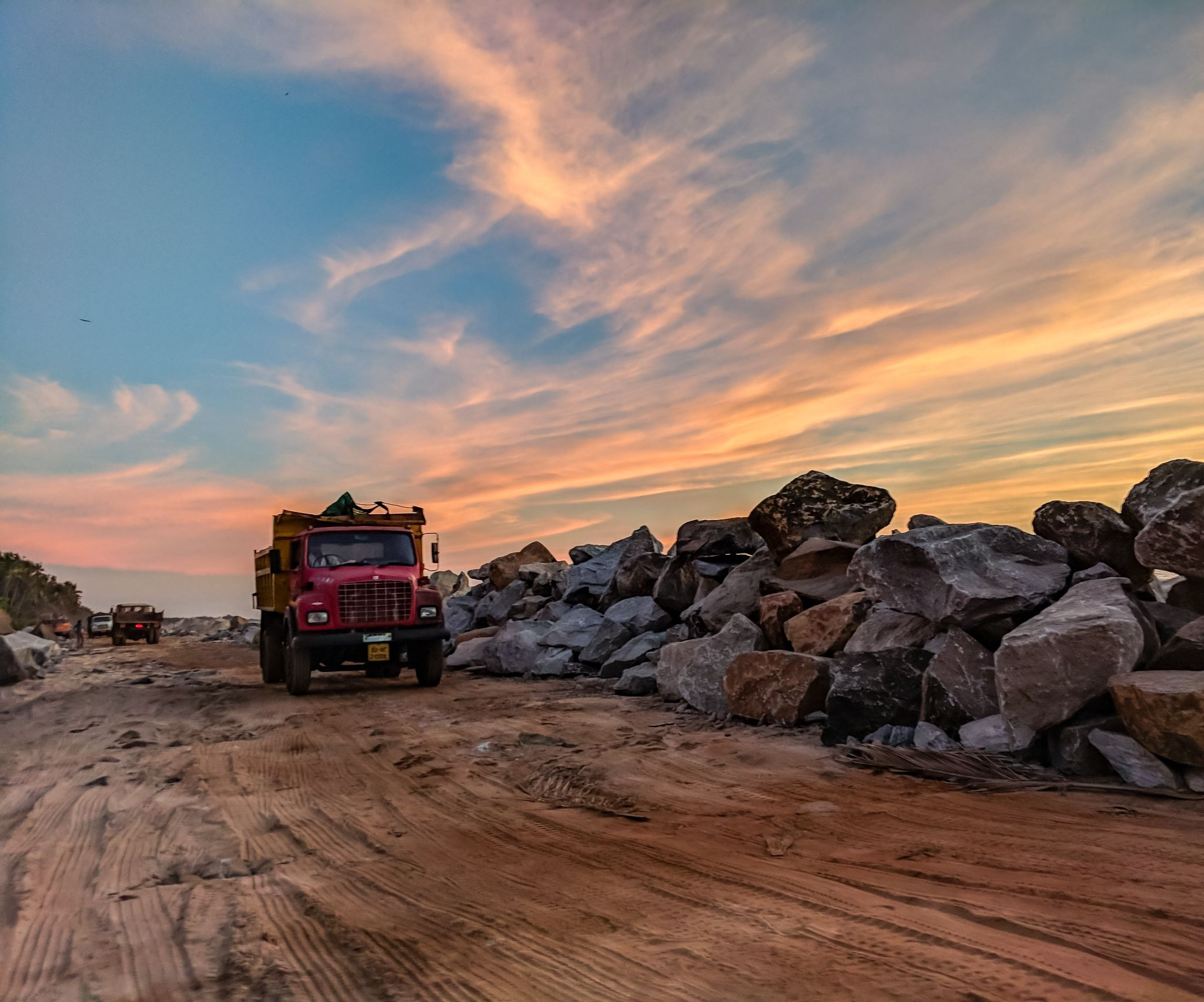 A semi truck driving on a dirt road