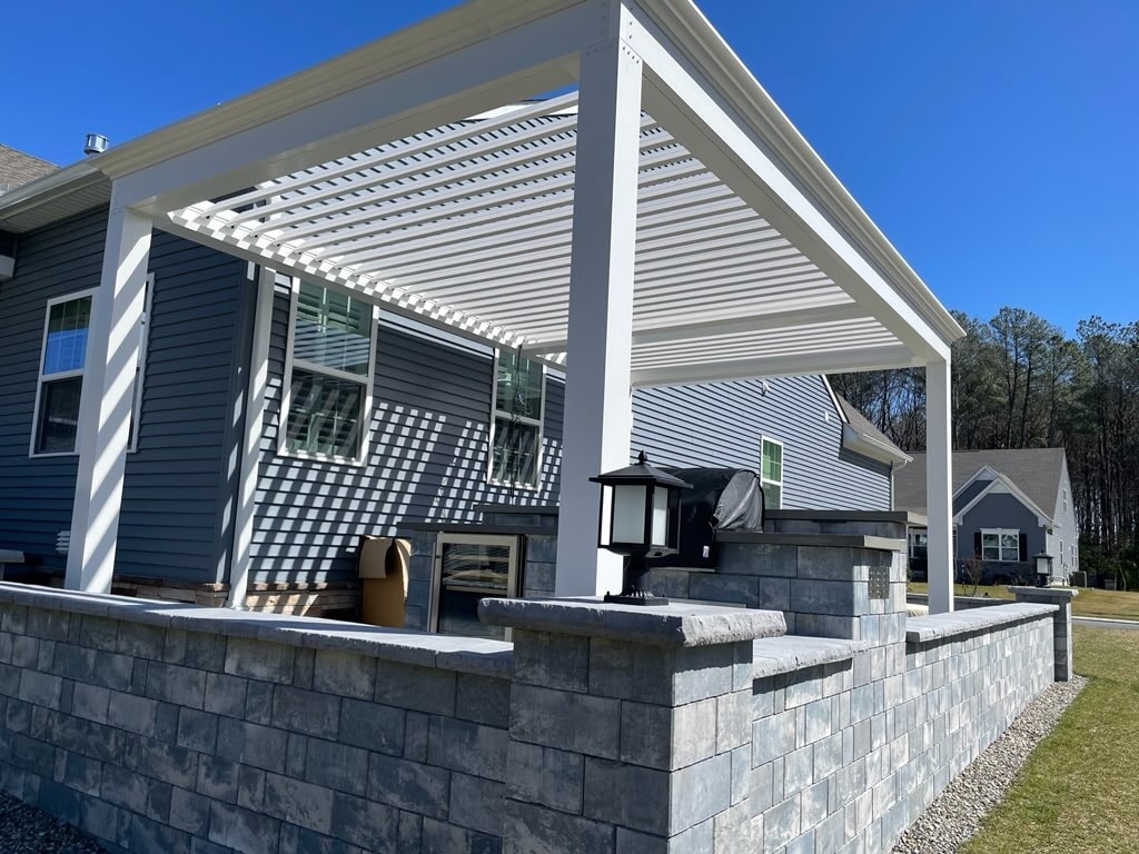 Tall pergola at right height next to house to accomodate an outdoor kitchen and sitting area