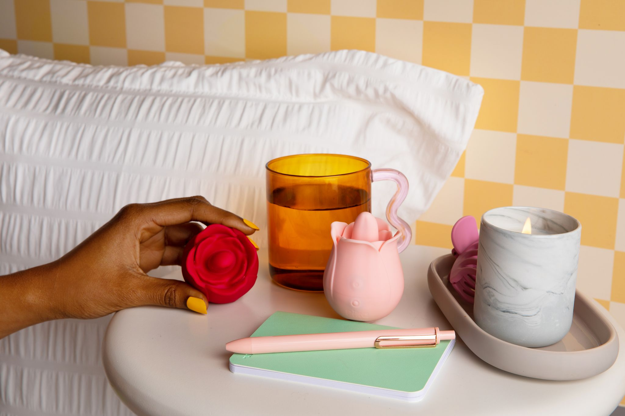 red and pink vibrating rose toys made from body safe silicone sitting on a night stand