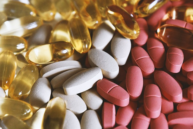 A close up of pills and vitamins; white, red and golden in color.