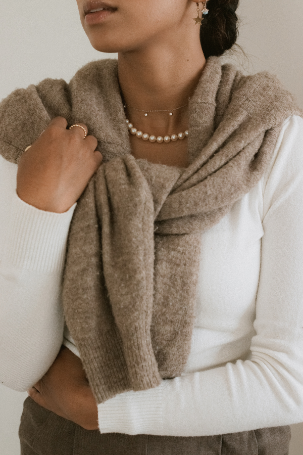 a woman wears a cozy sweater around her neck