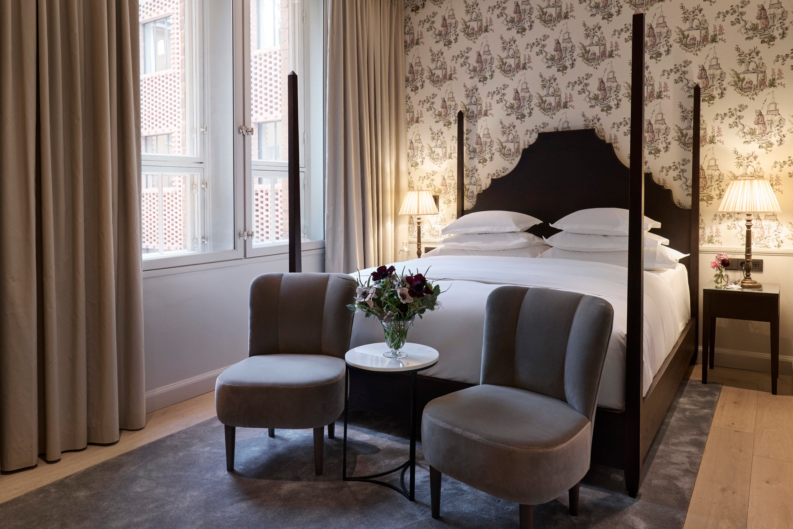 Ett hotellrum med säng och fåtöljer på Villa Dagmar i Stockholm.