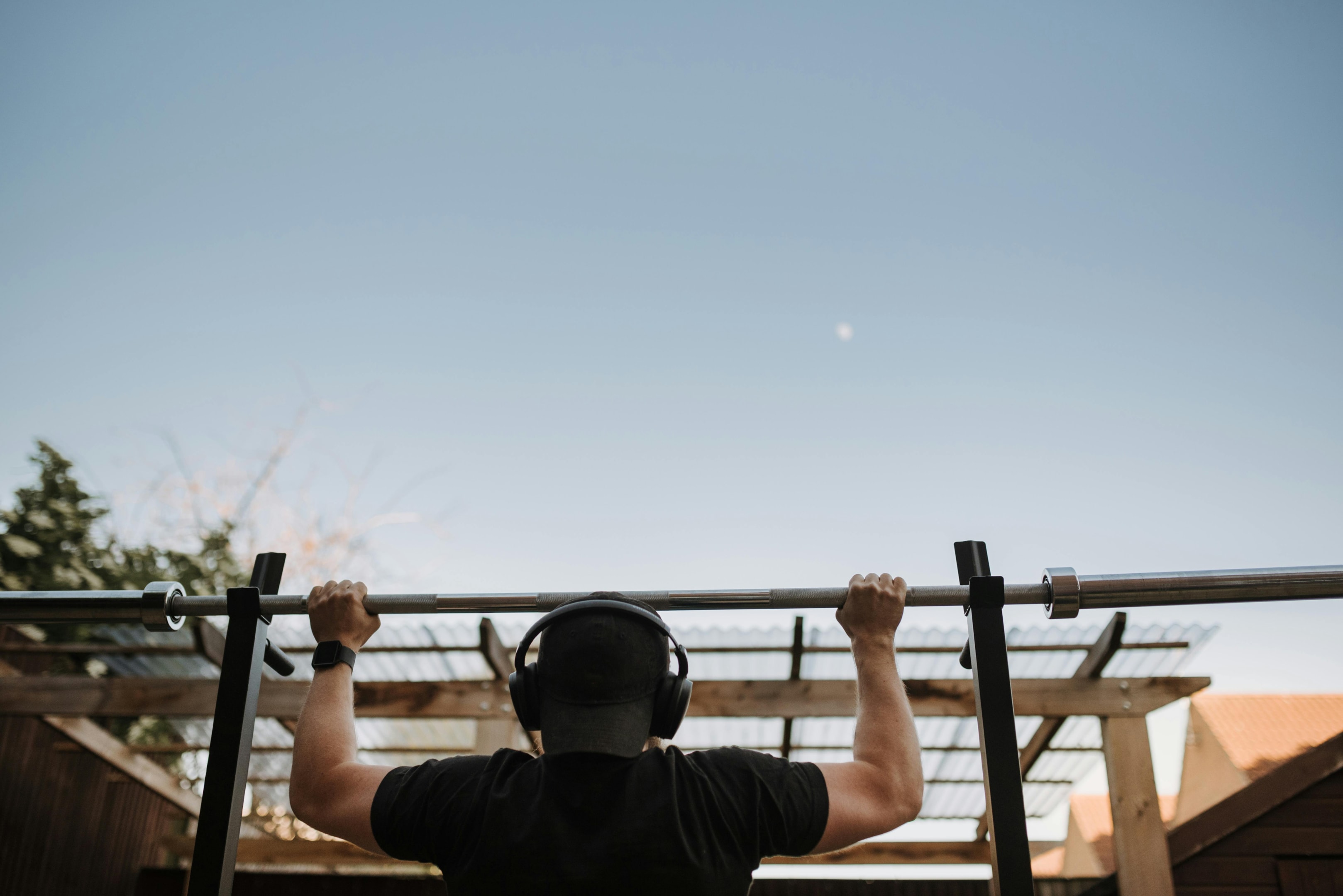 Photo by Anete Lusina: https://www.pexels.com/photo/unrecognizable-sportsman-in-headset-pulling-up-on-bar-on-street-4793376/