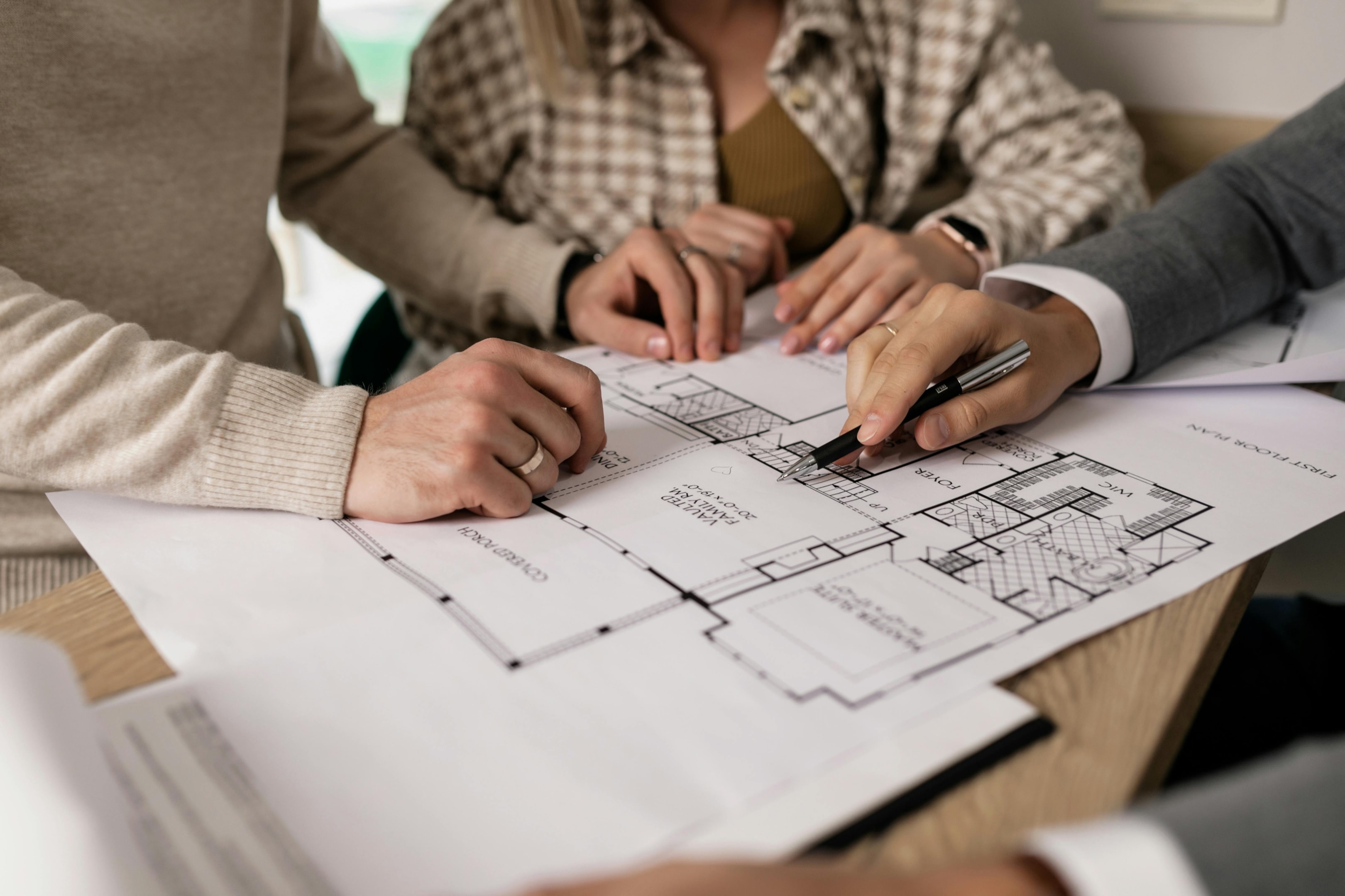 Real estate investor looks over house plans with motivated sellers in the negotiation stage. 