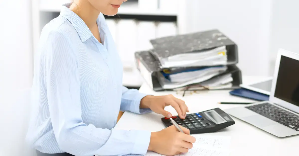Woman using managed accounting services to organize financial documents and track income.