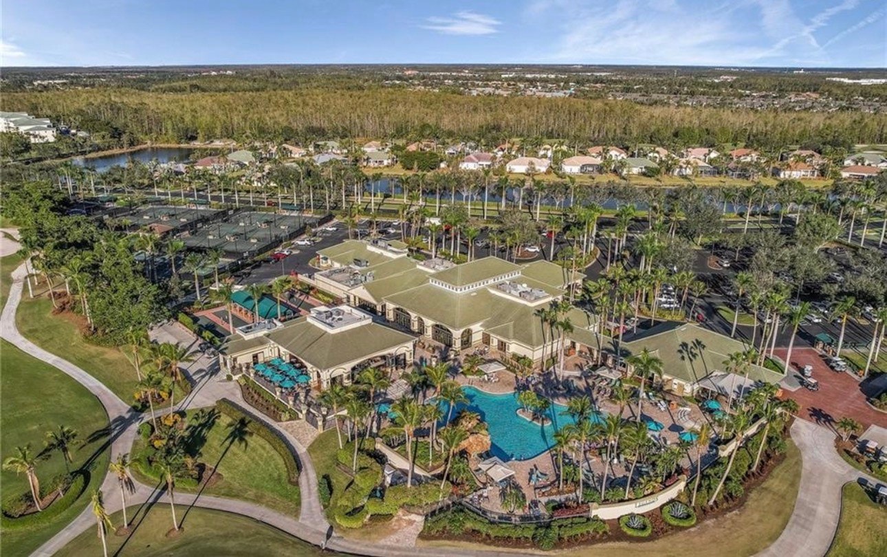 An aerial view showcases the stunning layout of a championship golf course at the Legends Golf and Country Club, featuring lush fairways, beautiful water features, and a sophisticated clubhouse in the background, all set within a picturesque gated community in Central Florida. This image highlights the top-notch golf facilities and amenities that offer a legendary experience for golfers and residents alike.