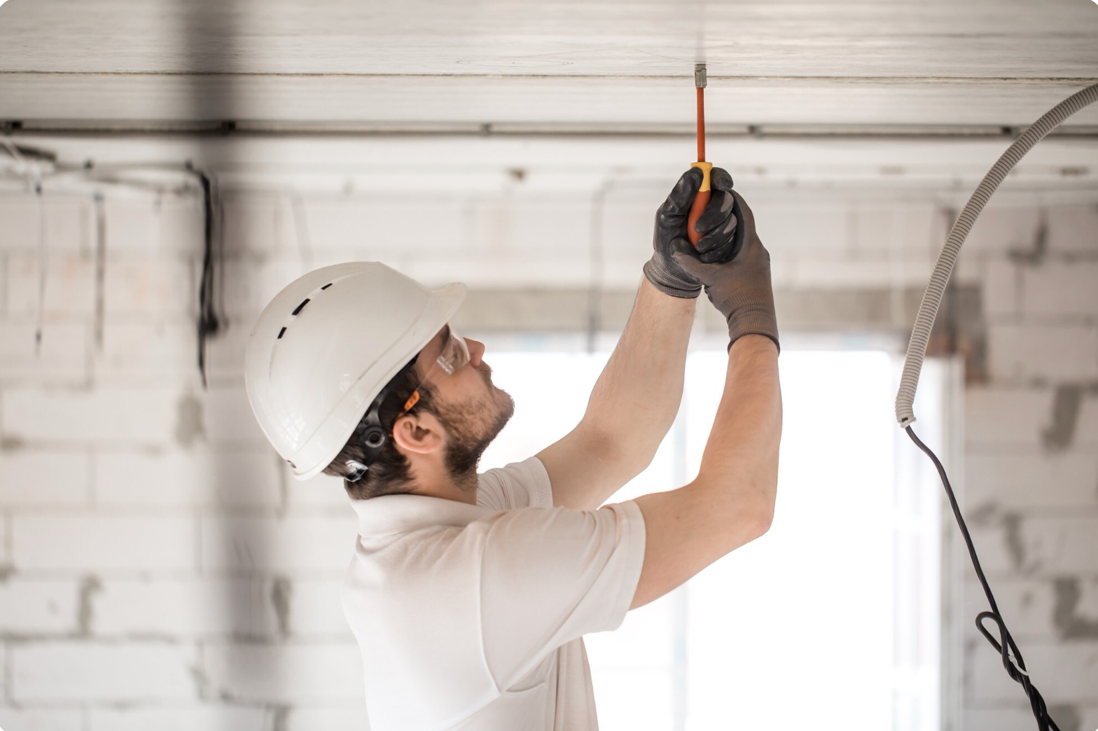 Electrician installer with a tool in his hands - https://www.freepik.com/free-photo/electrician-installer-with-tool-his-hands-working-with-cable-construction-site_10896432.htm#fromView=search&page=1&position=7&uuid=47af04c3-50b8-43ca-9c73-d4f8ca8acdfc&query=technicians+looking+at+ceiling