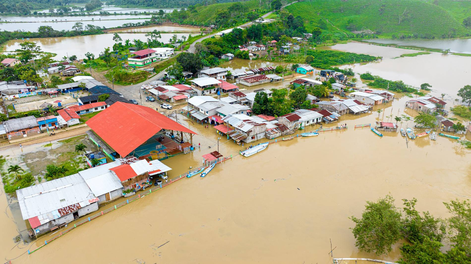 An aerial view of Muisne, Ecuador, showing the community's vulnerability to flooding, with houses surrounded by water. The image highlights the urgent need for sustainable, climate-resilient infrastructure and community-driven planning to address the challenges of sea-level rise and coastal erosion.