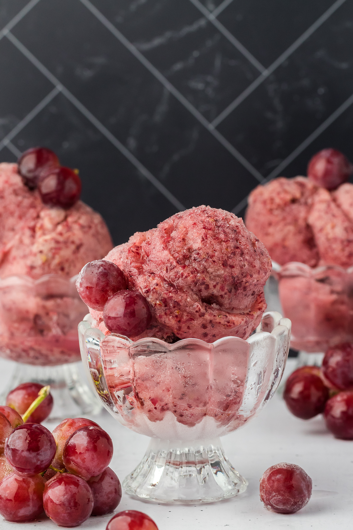 three dishes of grape sorbet topped with frozen grapes