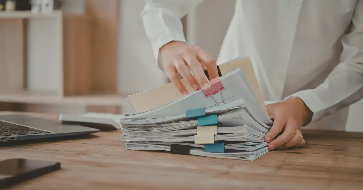 Woman sorting business expenses and folders while learning how to organize receipts for taxes.